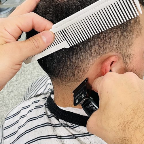 A man cutting his hair with a comb.