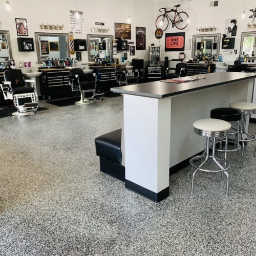 A barber shop with a counter and chairs, showcasing a cozy and inviting atmosphere for customers.